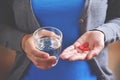 Female is holding red pills in heart shape. Royalty Free Stock Photo