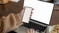 Female holding a smartphone and typing on laptop keyboard Royalty Free Stock Photo