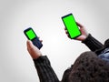 female holding two smart phones mock up in hands with green screen isolated Royalty Free Stock Photo
