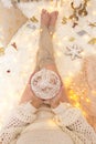 Female holds a glittering bauble among Chrismas decorations