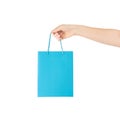 Female holds in hand blue clear empty blank craft paper gift bag for purchases after shopping isolated on white background with Royalty Free Stock Photo
