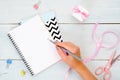 Female home office desk. Girl`s hand writing a text message in blank diary. Beauty blogger workspace concept. Fashion blog banner Royalty Free Stock Photo