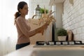 Female homeowner arrange bouquet from dry plants at kitchen counter
