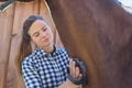 Female Horse Owner Cleaning Neck Of Her Bay Horse In The Stable During Daytime Royalty Free Stock Photo