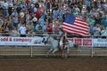 Female horseback rider carrying flag during opening ceremony at annual rodeo