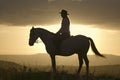 Female horseback rider and horse ride to overlook at Lewa Wildlife Conservancy in North Kenya, Africa at sunset Royalty Free Stock Photo