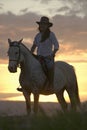 Female horseback rider and horse ride to overlook at Lewa Wildlife Conservancy in North Kenya, Africa at sunset Royalty Free Stock Photo