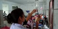 Female hospital staff collecting test sample into the glucose bottle