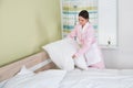 Female Housekeeper Arranging White Pillows On Bed Royalty Free Stock Photo