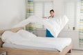 Female Housekeeper Changing Bedsheet On Bed Royalty Free Stock Photo