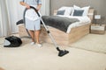Female housekeeper cleaning with vacuum cleaner Royalty Free Stock Photo