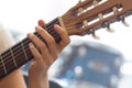 Female human hand playing an accoustic guitar holding a chord with strings Royalty Free Stock Photo