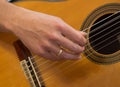 Female human hand playing an accoustic guitar strumming the strings