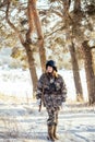 Female hunter in camouflage clothes ready to hunt, holding gun a Royalty Free Stock Photo