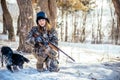 Female hunter in camouflage clothes ready to hunt, holding gun a