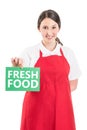 Female hypermarket worker holding fresh food sign