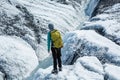 Female ice climbing guide looking over a water-filled crevasse on the Matanuska Glacier in Alaska