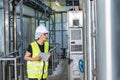 Female industrial engineer wearing a white helmet while standing in a heavy industrial factory Royalty Free Stock Photo