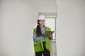 Female Industrial Engineer in White Hard Hat, High-Visibility Vest Working on Tablet Computer. Inspector or Safety Supervisor in