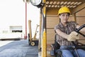 Female industrial worker driving forklift truck