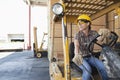 Female industrial worker looking away while driving forklift truck Royalty Free Stock Photo