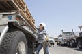 Female industrial worker strapping down wooden planks on logging truck Royalty Free Stock Photo