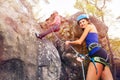 Instructor belaying girl rock climbing outdoors