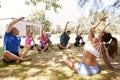 Female Instructor Leading Outdoor Yoga Class Royalty Free Stock Photo