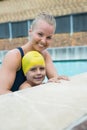 Female instructor and young boy relaxing at poolside Royalty Free Stock Photo