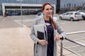 female insurance agent in the parking lot with a laptop looking into the distance with a smile Royalty Free Stock Photo