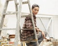 Female Interior Decorator Sitting On Ladder In Work Site