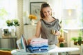 Female with iron, ironing board and clothes drinking coffee Royalty Free Stock Photo