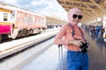 Female Islamic tourists hold cameras while waiting to travel