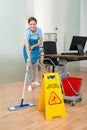 Female Janitor Cleaning Hardwood Floor In Office