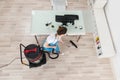 Female Janitor Cleaning Wooden Floor With Vacuum Cleaner Royalty Free Stock Photo