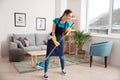 Female janitor having fun while cleaning flat Royalty Free Stock Photo