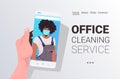 Female janitor in mask cleaner on smartphone screen self isolation online cleaning service concept Royalty Free Stock Photo