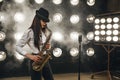 Female jazz musician in hat plays the saxophone