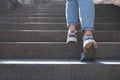 Female in jeans and sneakers going up steep stairs Royalty Free Stock Photo