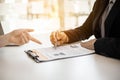 Female job applicants presenting a resume in the hands of a manager