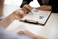 Female job applicants presenting a resume in the hands of a manager