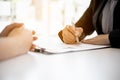 Female job applicants presenting a resume in the hands of a manager