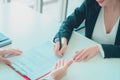 Female job candidate signing work contract with HR officer after a sucessful job interview