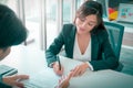 Female job candidate signing work contract with HR officer after a sucessful job interview