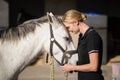 female jockey loving horse at barn