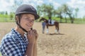 Female Jockey Putting On A Helmet And Getting Ready For Horse Riding Competition Royalty Free Stock Photo