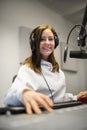 Female Jockey Smiling While Wearing Headphones In Radio Studio Royalty Free Stock Photo