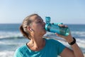 Female jogger drinking water on seaside Royalty Free Stock Photo