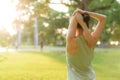 Female jogger. Fit young Asian woman with green sportswear stretching muscle in park before running and enjoying a healthy outdoor Royalty Free Stock Photo