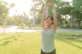 Female jogger. Fit young Asian woman with green sportswear stretching muscle in park before running and enjoying a healthy outdoor Royalty Free Stock Photo